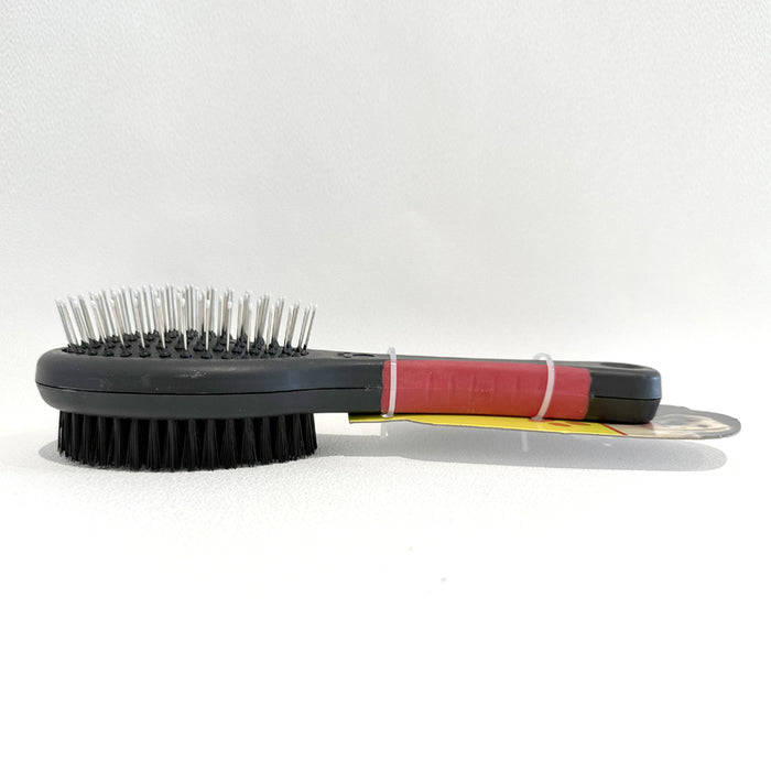 Double-sided grooming brush with a black base, red handle, metal bristles on one side, and soft bristles on the other.
