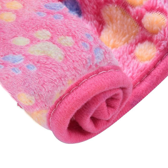 Bright pink pet mat featuring a soft, plush surface with colorful paw prints and rolled edges for warmth and comfort.